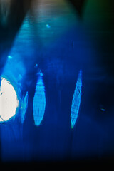 Macrophotographie abstraite d'une boule de verre colorée avec reflets lumineux bleus.