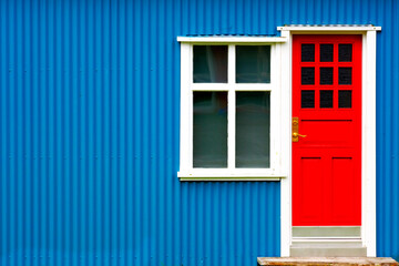Obraz premium Bright Red Door on Blue House with White Windows Colorful Archit