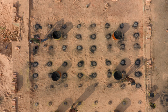 Aerial view of symmetrical patterns of round structures with dark shadows contrasting against the light-colored ground, Dhaka, Dhaka Division, Bangladesh.
