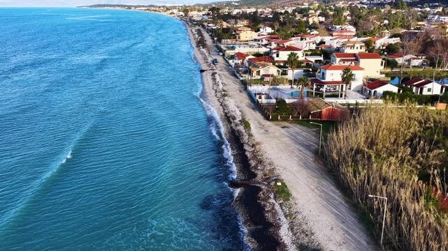 Drone shot of beachfront houses and hotels along the coastline of Roda and Acharavi with blue Ionian Sea in Corfu Island, Greece