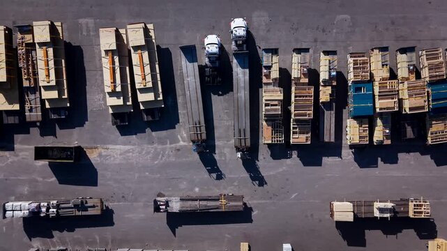 Aerial overhead view of parking lot with truck and trailers carrying construction materials