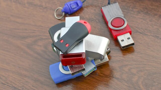Close-up of assorted USB drives on a wooden surface, offering stylish storage options. Variety of USB drives in detail, providing storage solutions on a wooden base.