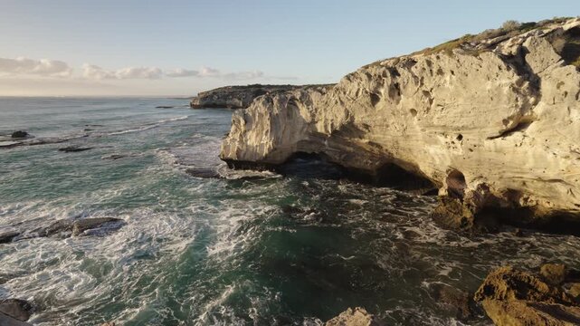 4k 60p footage of the rocky coastline near Waenhuiskrans Cave, Arniston. Towering cliffs meet ocean waves in Overberg seascape, Western Cape, South Africa. Ideal for nature and travel visuals.