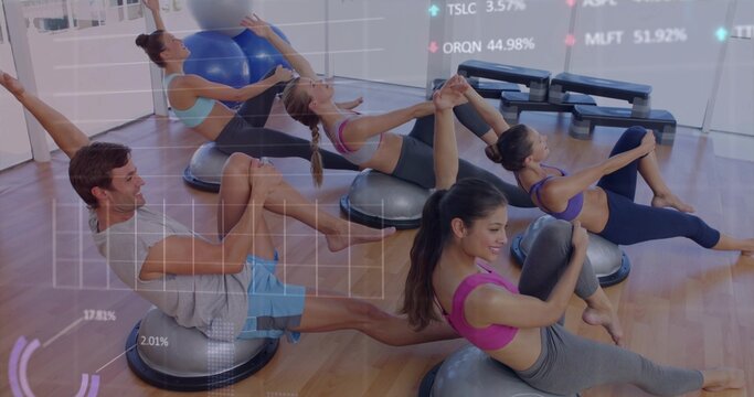 Performing core balance moves five in sportswear holding legs on BOSUs in studio, near mirrors
