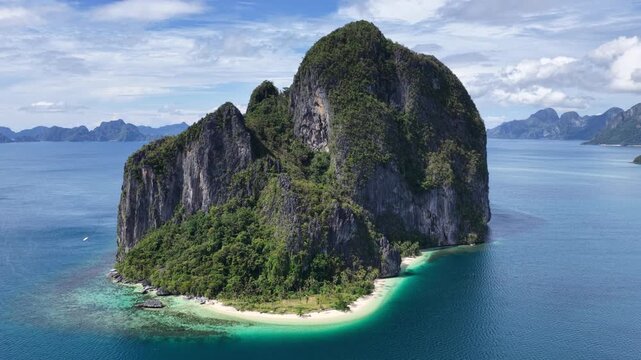 Cinematic aerial video of tropical island in the Philippines with lime stone rock, palm trees and beautiful beach