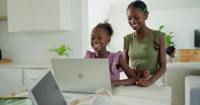 African American sisters teen  and  child cheering laptop win in kitchen older picking headset worki