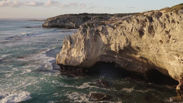 4k 60p footage of the rocky coastline near Waenhuiskrans Cave, Arniston. Towering cliffs meet ocean waves in Overberg seascape, Western Cape, South Africa. Ideal for nature and travel visuals.