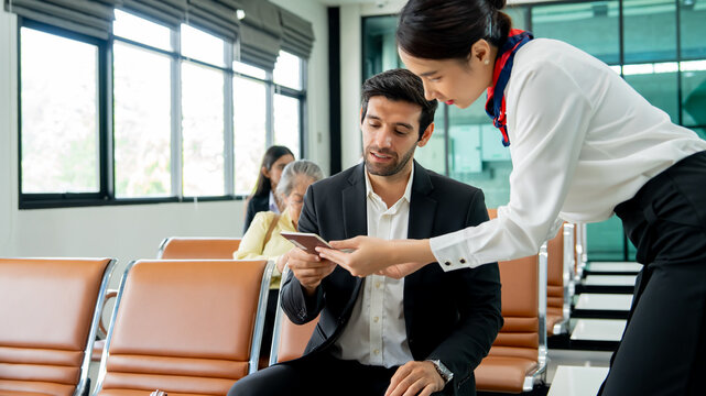 Business traveler showing passport to airline staff while sitting in airport lounge waiting area. Concept of airport passenger service air travel process, and international business travel.
