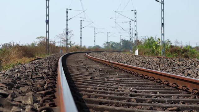 Close low angle view of curved railway track with electrified overhead lines