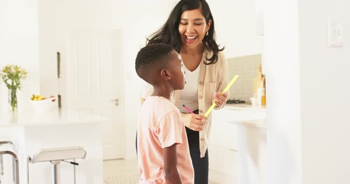 Latina mom and African American boy leaning, marking wall at home with pink pencil ruler hugging