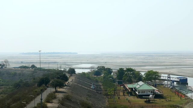 Dibrugarh, Assam, India &ndash; 12 March 2026: Wide view of the Brahmaputra riverbed with riverside buildings, roads, and infrastructure near the riverbank under a clear sky in northeastern India.