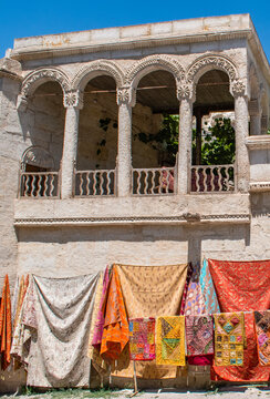 Cappadocia, Turkey: fabrics and carpets for sale displayed under an ancient arched building in Mustafapasa, formerly known as Sinasos, famous for its imposing, finely decorated stone house