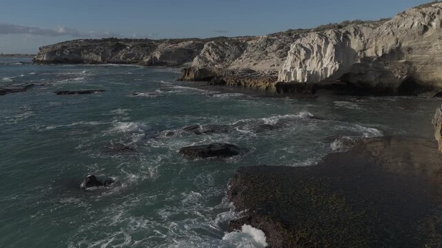 4k 60p footage of the rocky coastline near Waenhuiskrans Cave, Arniston. Towering cliffs meet ocean waves in Overberg seascape, Western Cape, South Africa. Ideal for nature and travel visuals.