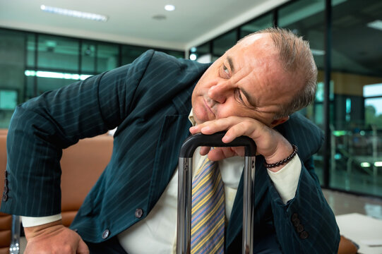 Elderly businessman feeling bored and sleepy while waiting going onboard for too long because of delay flight