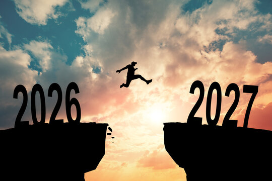 Silhouette of a person jumping between the years 2026 and 2027, symbolizing progress and moving forward. The image captures the essence of ambition and the passage of time.