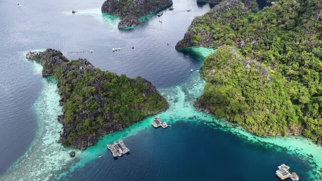 Cinematic aerial video of house boats in azure blue water lagoons with limestone cliffs at tropical islands of Coron in the Philippines 