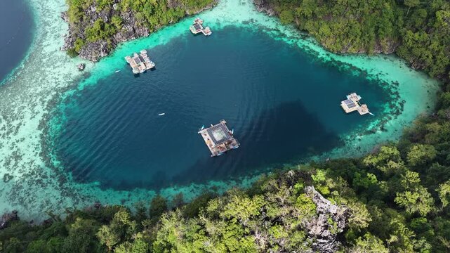 Cinematic aerial video of house boats in azure blue water lagoons with limestone cliffs at tropical islands of Coron in the Philippines 
