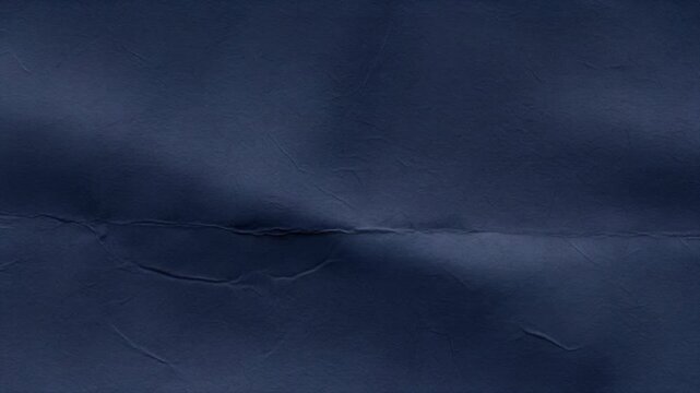 A dark blue, crumpled, and slightly shiny surface with creases and folds