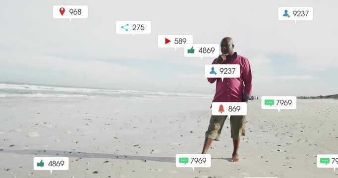 Vertical video: Walking man in pink shirt approaching, talking on phone while icons rising on beach