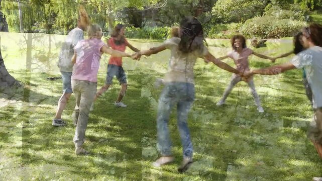 Joining hands adult circle moving clockwise across mown lawn skipping tightening for team building