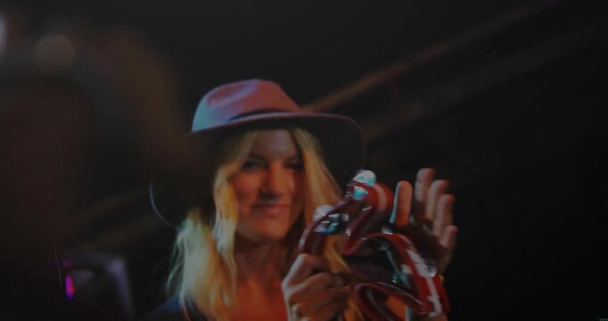 Vertical video: Musician raising tambourine shaking tapping making sparks round hat accenting beat