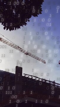 Vertical video: Cam tilting, crane lowering load for construction as binary overlay grows