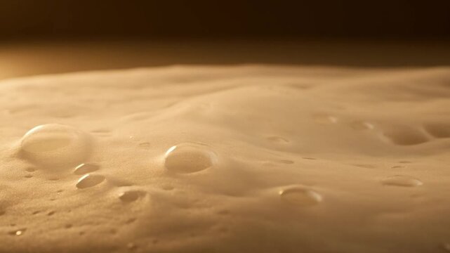 Creamy foam cleanser macro texture video with soft soap lather peaks on glossy liquid surface, skincare hygiene beauty purity abstract cleansing background