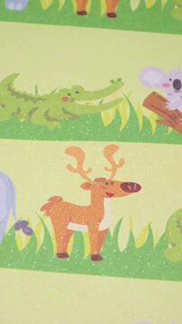 Close-Up Movement Over Decorative Animal Illustrations Including a Deer, Crocodile, Lion, Koala, and Bear on a Sparkling Pale Green Background, Vertical Panning Shot of a Cute Animal Pattern 