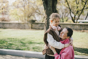 Happy mother and daughter relaxing in a park on sunny day.