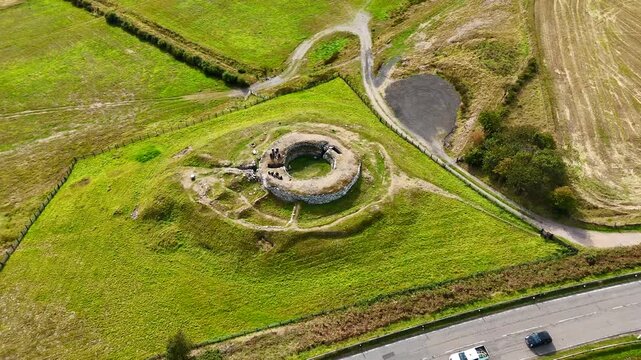 Wide Aerial Pan of the Isolated Carn Liath Broch Stone Ruins, Historical Celtic Settlement in the Wild Grasslands of Northern Scotland, United Kingdom