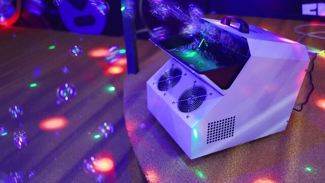 Bubble machine. Soap bubble generator in operation. Representation of soap bubbles at the birthday party.