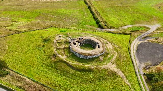 Cinematic Drone Shot of the Ancient Carn Liath Broch Ruins Surrounded by Rugged Scottish Landscape and Green Meadows, North Coast 500 Route, Scotland