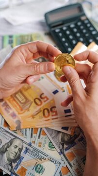 Hands toss and rotate BTC bitcoin against the dollars and euros