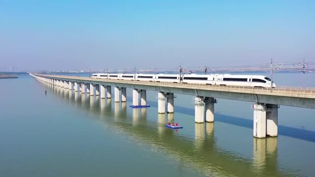 Aerial shot of a high-speed train speeding across the Dankun Super Major Bridge