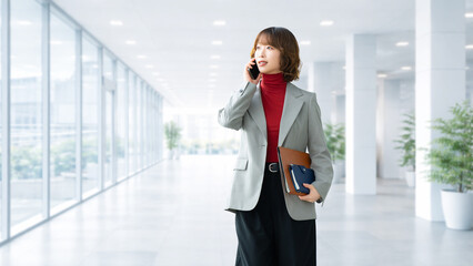 スマートフォンで通話するビジネスウーマン オフィスで連絡する女性のビジネスイメージ, Businesswoman Talking on Smartphone in Office Communication Concept © Trickster*