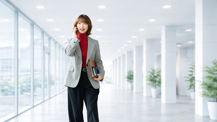 スマートフォンで通話するビジネスウーマン オフィスで連絡する女性のビジネスイメージ, Businesswoman Talking on Smartphone in Office Communication Concept © Trickster*