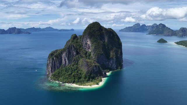 Cinematic aerial video of tropical island in the Philippines with lime stone rock, palm trees and beautiful beach