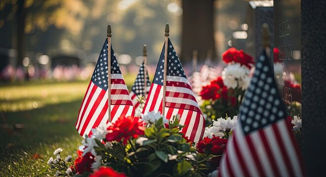 American flags and flowers at a memorial or cemetery on a sunny day