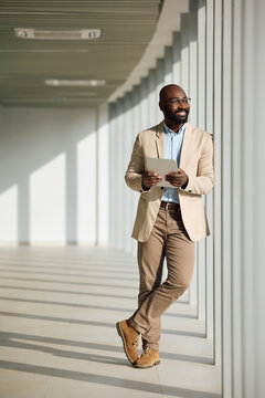 Full length of happy black businesswoman working on touchpad in the office.
