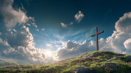 Naklejka premium A large wooden cross stands on a grassy hill under a bright blue sky with fluffy white clouds and sun rays.