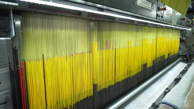 Industrial machinery manufacturing patterned carpets in a large scale textile production facility