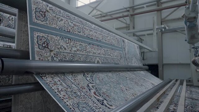 Automated industrial machinery processing a patterned carpet on a textile factory production line