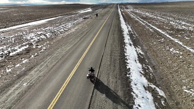 Man riding adventure motorcycle on the iconic Route 40 (Ruta 40) in Santa Cruz. Endless highway through the Patagonian steppe.