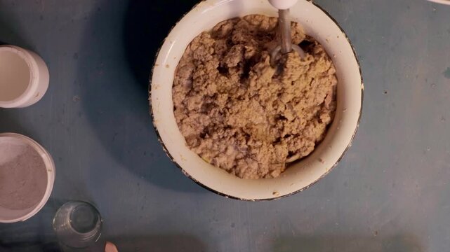 Step 3 of papier mache process. Hands squeezing soaked recycled paper pulp to remove water and prepare material for handmade craft mixture