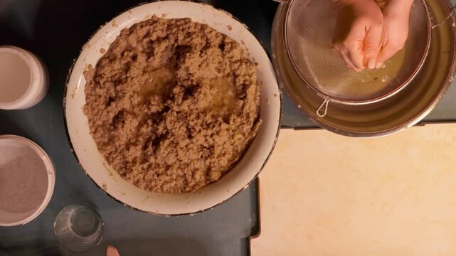 Step 3 of papier mache process. Hands squeezing soaked recycled paper pulp to remove water and prepare material for handmade craft mixture