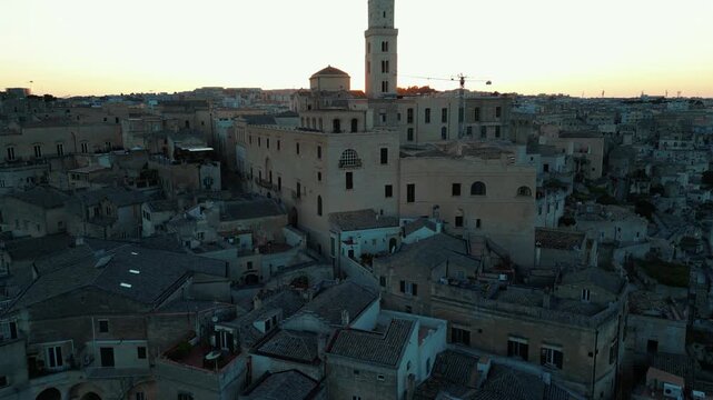 View approaching Matera, with its church hiding the sunset, in Italy