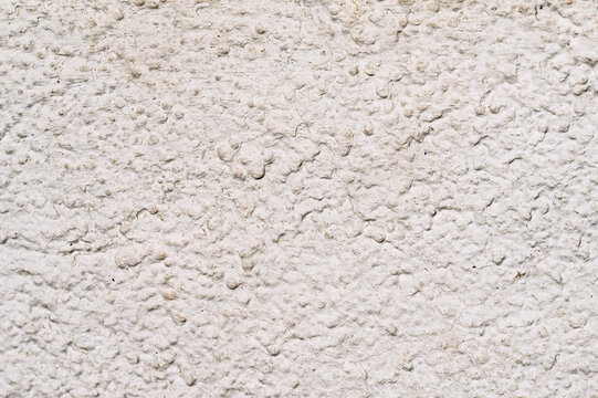 Texture de cr&eacute;pi blanc cass&eacute; sur un mur ext&eacute;rieur, gros plan.