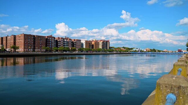Watching the peaceful river flowing through the city. At the quay of the waterscape near the park. Blocks of flats at the other waterfront.