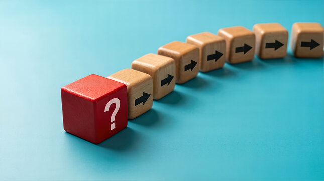 Wooden domino blocks with black arrows lined up in curved path leading to red question mark block
