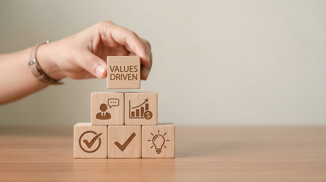 Prioritizing core values for business success Hand places 'VALUES DRIVEN' block on strategic icons, illustrating commitment to ethical growth and professional development